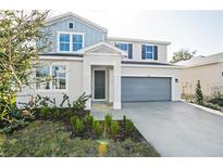 Two-story home with gray and blue exterior, two-car garage, and landscaping at 1740 Carnelian St, Deland, FL 32720