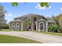 Stunning two-story home featuring arched windows, manicured landscaping and a long driveway at 1810 Markham Woods Rd, Longwood, FL 32779