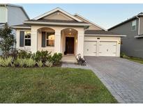 Two-car garage and front yard with paver driveway at 14827 Milfoil Ave, Orlando, FL 32827