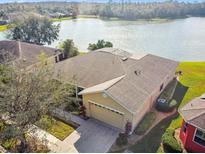 Inviting home boasts a paver driveway and mature landscaping with stunning lake views at 256 New River Dr, Poinciana, FL 34759