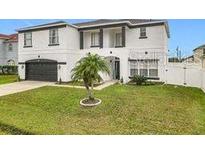Two-story house with white exterior, black accents, and a two-car garage at 269 Beckenham Dr, Kissimmee, FL 34758