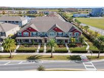 Inviting townhomes featuring manicured landscaping, vibrant colors and a sidewalk with street access at 9475 Randal Park Blvd, Orlando, FL 32832