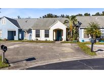 Front view of a light blue house with a teal door, landscaping, and driveway at 116 Candlewick Ct, Sanford, FL 32771
