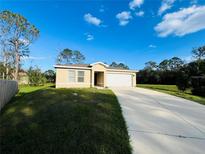 Single-story house with a two-car garage and a well-maintained lawn at 1421 Swift Ct, Poinciana, FL 34759