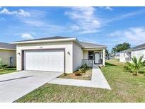 Single-story home with attached garage and landscaped yard at 285 N Kentucky Ave, Umatilla, FL 32784