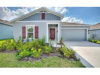 One-story home with gray siding, red shutters, and a two-car garage at 313 Loch Ct, Davenport, FL 33837