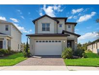 Two-story home with a two-car garage and landscaped lawn at 3224 Oxbow Ct, Harmony, FL 34773
