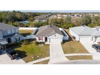 Inviting single-story home featuring a well-manicured lawn, two-car garage, and white picket fence at 3573 Bristol Cove Ln, St Cloud, FL 34772