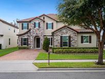 Two-story house with stone accents and a brick driveway at 8358 Lookout Pointe Dr, Windermere, FL 34786