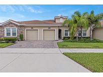 Two-car garage, attractive landscaping, and a brick facade at 1066 Quaker Ridge Ln, Davenport, FL 33896