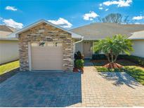 Front view of a single-story home with stone accents and a paved driveway at 2664 Shelby Ruth Pl, Saint Cloud, FL 34769