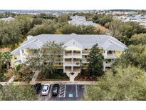 Aerial view of a yellow building with multiple units, parking, and landscaping at 312 Lucaya Loop # B5/U312, Davenport, FL 33897