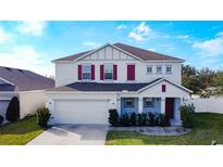 Two-story house with gray siding, red shutters, and a two-car garage at 524 Sardinia Cir, Davenport, FL 33837