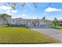 Ranch-style home with a well-maintained lawn and driveway at 7804 Acadian Dr, Orlando, FL 32822