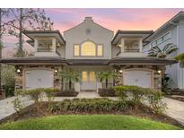 Elegant two-story home featuring dual garages, balconies, manicured landscaping, and a charming, symmetrical facade at 8162 Valhalla Ter, Reunion, FL 34747