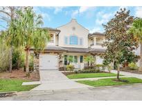 Elegant two-story townhome featuring a stone facade, arched windows, and lush landscaping in a well-maintained community at 8162 Valhalla Ter, Reunion, FL 34747
