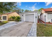 Front view of a house with a driveway and garage at 103 Las Flores, Winter Haven, FL 33884