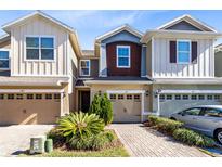 Three-story townhouses with attached garages and landscaped front yards at 1311 E 10Th St, Apopka, FL 32703