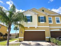 Inviting two-story home with a well-maintained lawn, lush palm tree, and a spacious two-car garage at 272 Muscogee Ln, Orlando, FL 32825