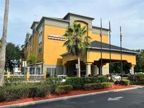 Hotel exterior featuring a multi-story building with ample parking at 3000 Maingate Ln # 228, Kissimmee, FL 34747