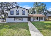 Two-story home with a well-manicured front yard and a patterned walkway leading to the front door at 3020 Rockingham Cir, Orlando, FL 32808