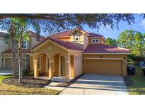 Two-story house with terracotta roof and attached garage at 384 Orange Cosmos Blvd, Davenport, FL 33837