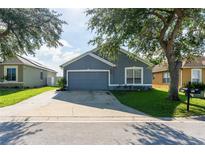 House exterior showcasing a gray painted facade and a driveway at 435 Madina Cir, Davenport, FL 33837