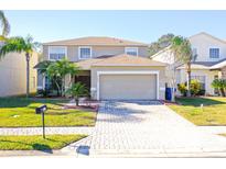 Two-story house with a paved driveway and landscaping at 4608 Cumbrian Lakes Dr, Kissimmee, FL 34746