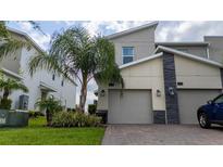 Modern two-story home with attached two-car garage and landscaping at 701 Ocean Course Ave, Davenport, FL 33896