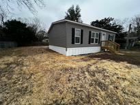 Gray single-wide manufactured home with a wooden deck at 1134 Nw 44Th St, Ocala, FL 34475