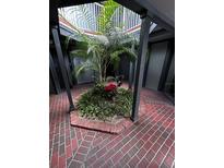 Ground level view of a courtyard with brick flooring and tropical plants at 3984 Atrium Dr # 4, Orlando, FL 32822
