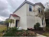 Two-story house with light-colored exterior and Spanish-style roof at 4562 Corsa Ln, Kissimmee, FL 34746