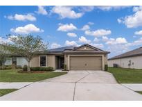 House exterior featuring a two-car garage and solar panels at 661 Swallowtail Dr, Haines City, FL 33844