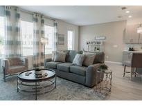 Bright living room features a comfy sofa and large windows at 800 Benoi Dr, Davenport, FL 33896