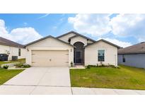 One-story home with attached garage and well-manicured lawn at 1606 Steely Dr, Dundee, FL 33838
