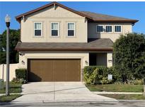 Inviting two-story home featuring a well-manicured lawn, brown accents, and an attached two-car garage at 2211 Bittle Way, St Cloud, FL 34769