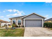 Gray house with stone accents, two-car garage, and landscaped yard at 540 E 19Th St, St Cloud, FL 34769