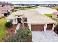 Single-story home with tile roof, two-car garage, and lake view at 644 San Raphael St, Kissimmee, FL 34759