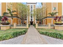 Resort-style building exterior with palm trees and walkway at 12544 Floridays Resort Dr, Orlando, FL 32821