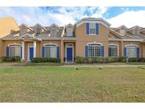 Tan two-story house with blue shutters and a manicured lawn at 1933 Island Walk Dr, Orlando, FL 32824