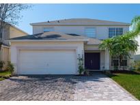Charming two-story home with a brick driveway, attached garage, and well-manicured lawn at 4626 Cumbrian Lakes Dr, Kissimmee, FL 34746