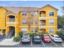 Exterior view of a yellow building with parking and landscaping at 8848 Villa View # 106, Orlando, FL 32821