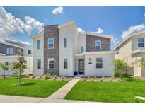 Two-story modern home with stone accents and landscaped lawn at 9194 Sommerset Hills Dr, Davenport, FL 33896