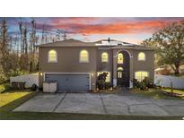 Two-story house with gray garage door and solar panels on the roof at 212 Rontunda Dr, Kissimmee, FL 34758