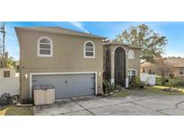 Two story home featuring a two-car garage, neutral color scheme, and well-maintained landscaping at 212 Rontunda Dr, Kissimmee, FL 34758