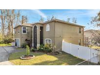 Charming two-story home featuring a well-manicured lawn and a white fence at 212 Rontunda Dr, Kissimmee, FL 34758