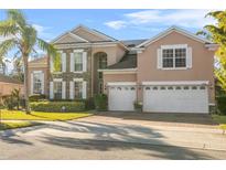 Two-story house with a three-car garage and solar panels at 2136 Laurel Blossom Cir, Ocoee, FL 34761