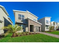 Modern two-story home with stone accents and landscaped lawn at 2746 Bookmark Dr, Kissimmee, FL 34746