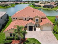 Luxury home with lake view, large yard, and tile roof at 880 Spinnaker Way, Kissimmee, FL 34746