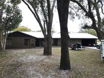 Brick ranch house with mature trees, a large yard, and a metal roof at 1085 Old Hickory Tree Rd, St Cloud, FL 34771